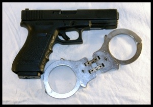 A picture of a pistol and handcuffs